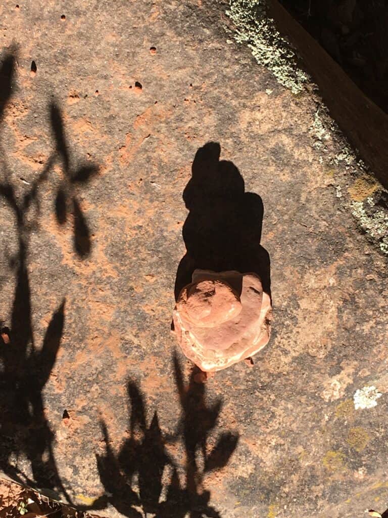 photo of a cairn and its shadow, looking from above