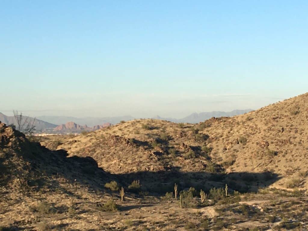 photo of desert mountains with long shadows from sunset