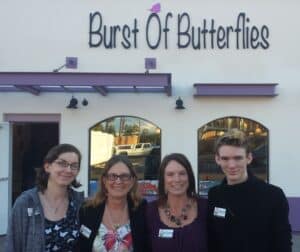 photo of the family standing in front of the Burst of Butterflies storefront